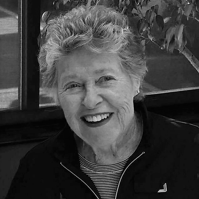 Description: A black and white photo of an older woman, possibly one of the women's basketball hall of fame members, smiling.