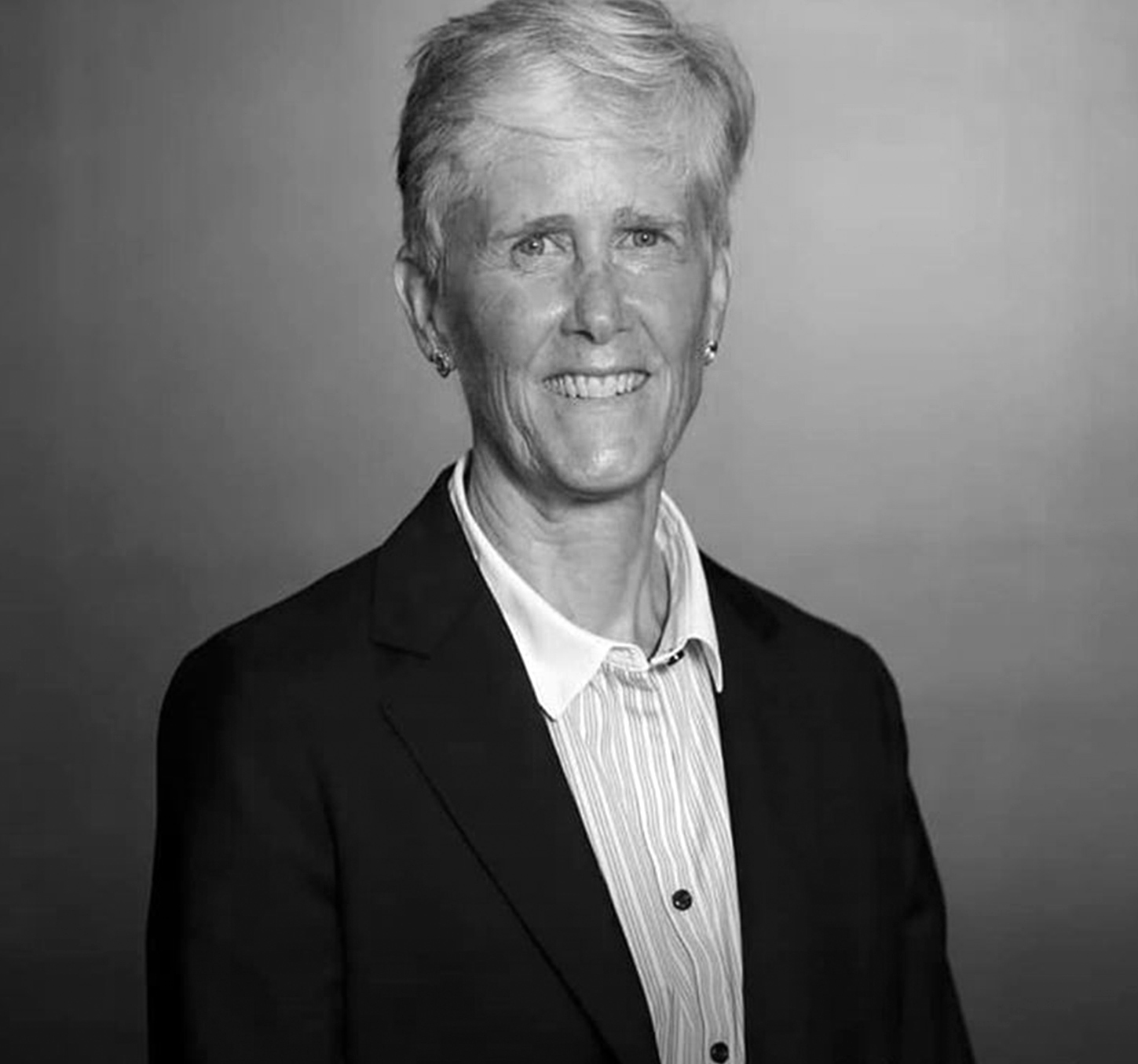 A black and white photo of a woman in a suit.