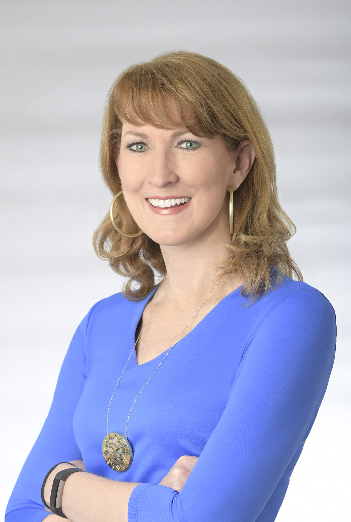 A smiling woman in a blue shirt.