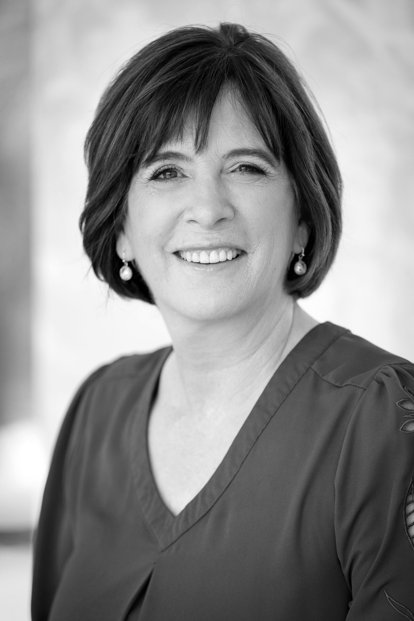 A black and white photo of a woman smiling.