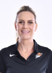 A woman in a black polo posing for a photo.