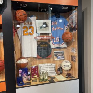 A display case with basketball memorabilia and other items.