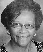 A black and white photo of an older woman wearing glasses.