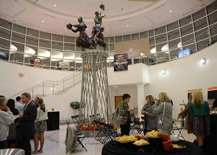 A group of people standing around a table at a Hall of Fame event.