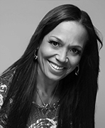 A woman with long hair, who is a women's basketball hall of fame member, smiling.