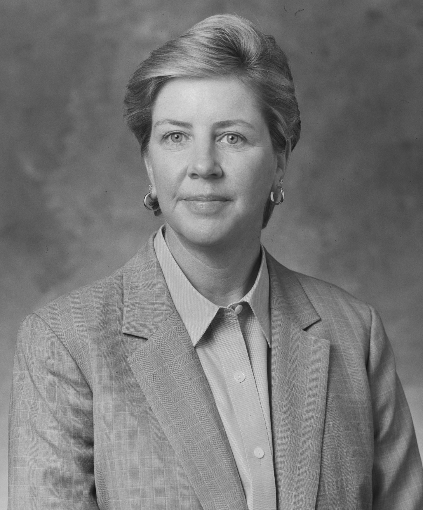 A black and white photo of a woman in a suit.