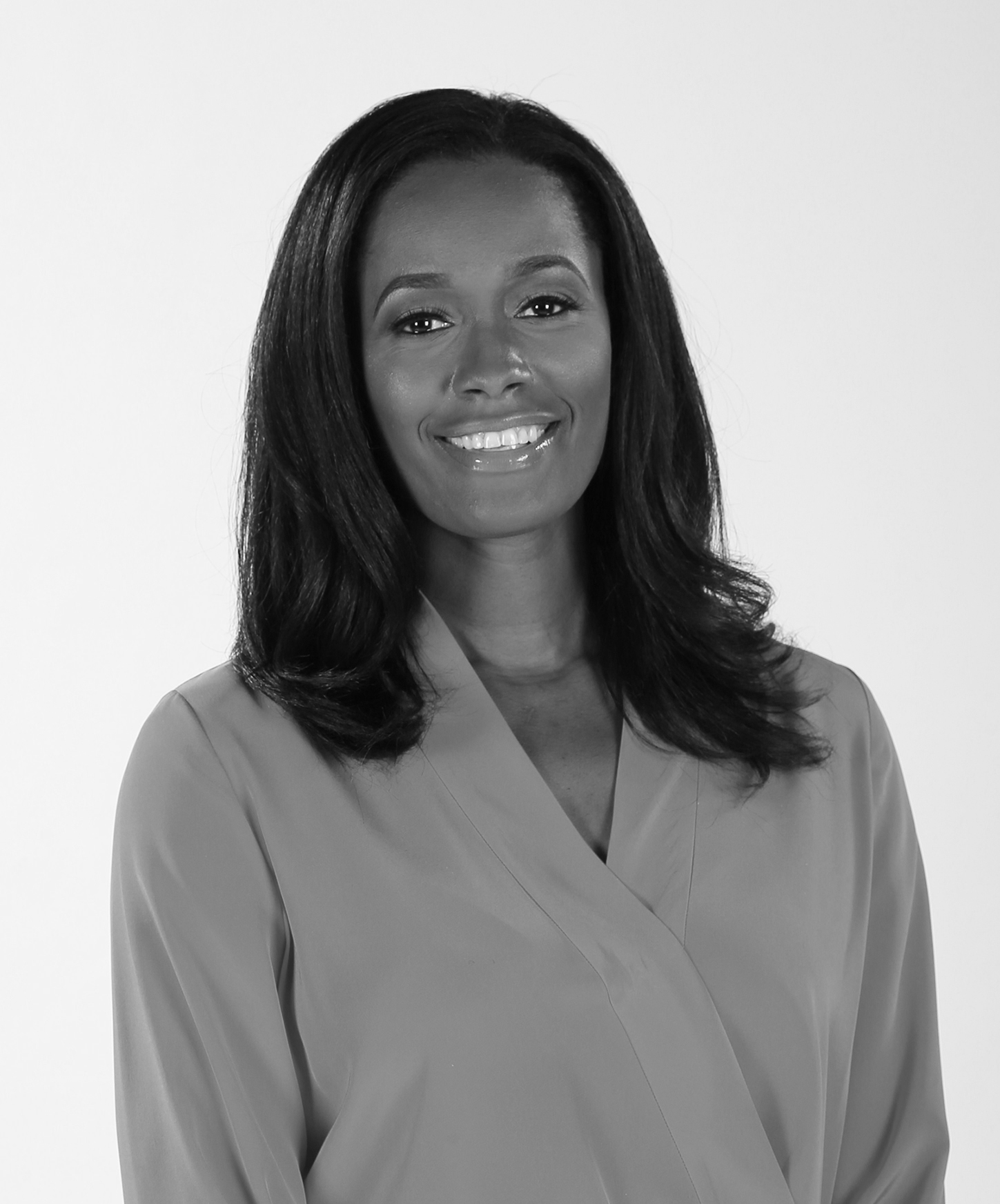 A black woman smiling in a gray shirt.