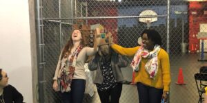 A group of people standing in front of a fence.