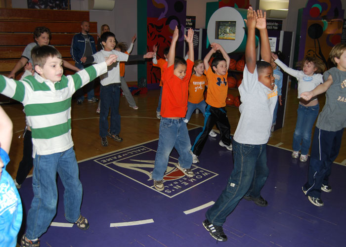 A group of kids participating in Hall of Fame Youth Events, playing Wii.