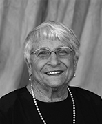 A black and white photo of an older woman smiling.