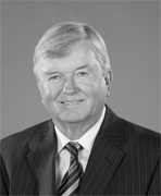 A black and white photo of an older man in a suit.