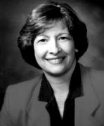 A black and white photo of a woman smiling.