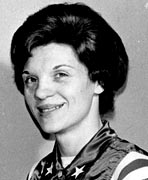 A black and white photo of a woman in an american flag vest.