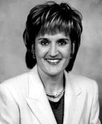 A black and white photo of a woman in a suit.