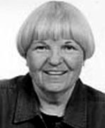 A black and white photo of an older woman smiling.