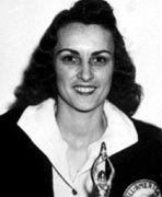 A black and white photo of a woman holding a trophy.