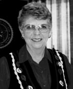 A black and white photo of a woman in a vest.