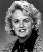 A black and white photo of a woman in a suit.