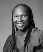 A black and white photo of a woman with dreadlocks.