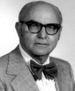 A black and white photo of an older man wearing glasses and a bow tie.