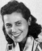 A black and white photo of a woman smiling.