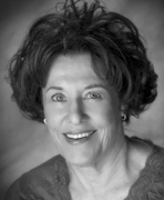 A black and white photo of an older woman smiling.