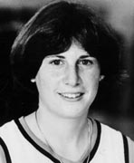 A black and white photo of a woman in a basketball uniform.