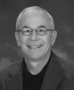 A black and white photo of an older man smiling.