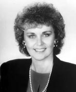 A black and white photo of a woman in a suit.