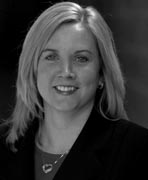 A black and white photo of a woman in a business suit.