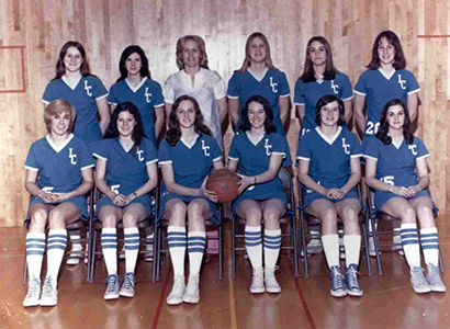 A group of women, women's basketball hall of fame members, in blue basketball uniforms posing for a photo.