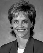 A black and white photo of a woman smiling.