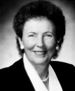 A black and white photo of a woman in a suit.