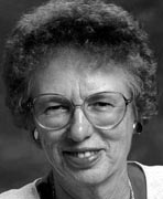 A black and white photo of an older woman with glasses.