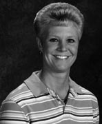 A black and white photo of a woman in a striped shirt.