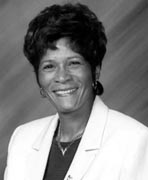 A black and white photo of a woman smiling.