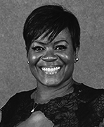 A black and white photo of a woman smiling.