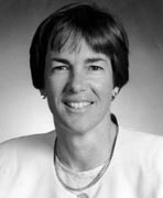 A black and white photo of a woman smiling.