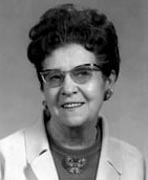 A black and white photo of an older woman wearing glasses.