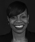 A black and white photo of a smiling woman.