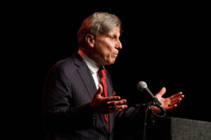 A man in a suit, recipient of the prestigious Berenson Trophy, speaking into a microphone.