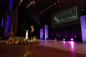 A woman receiving the Berenson Trophy on stage at the Women's National Hall of Fame.