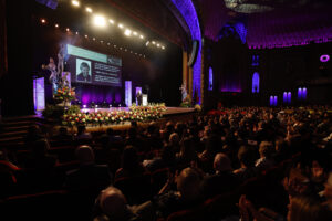 A large auditorium filled with many people in the audience eagerly awaiting the announcement of the prestigious Berenson Trophy.