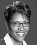 A black and white photo of a woman wearing glasses.