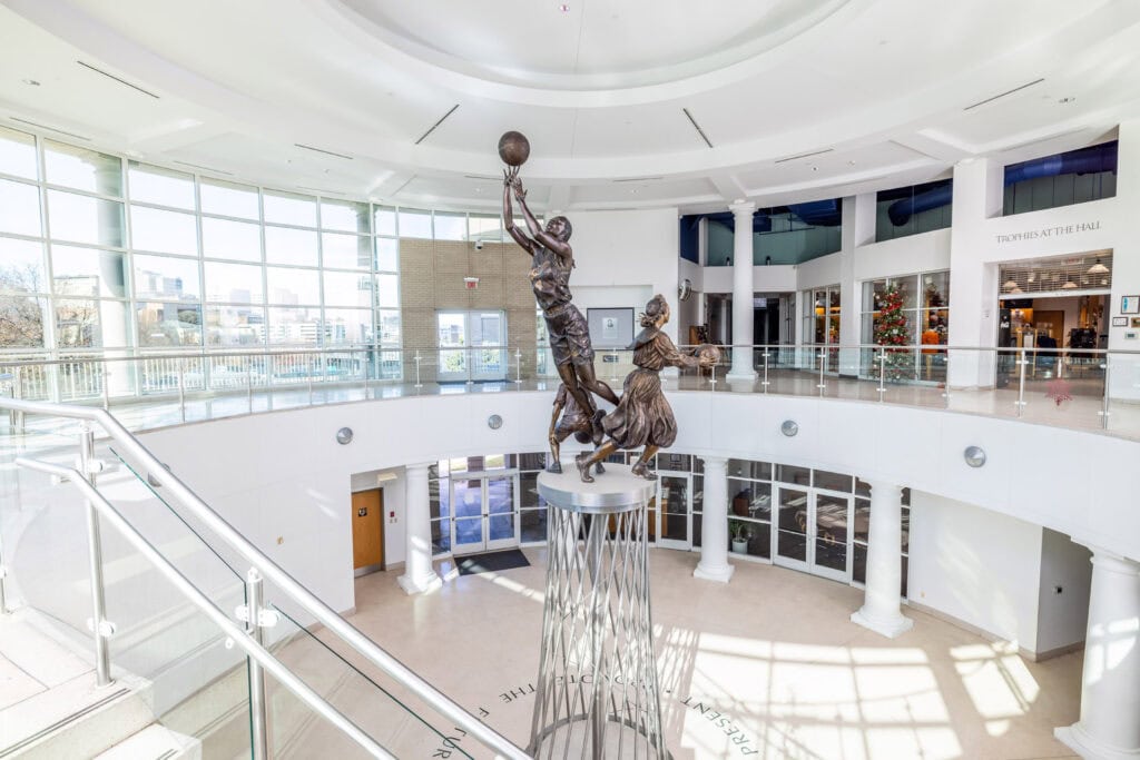 A statue of a basketball player in the lobby of a building.