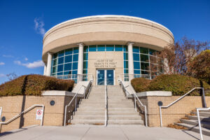 A circular basketball hall of fame building with stairs leading up to it.