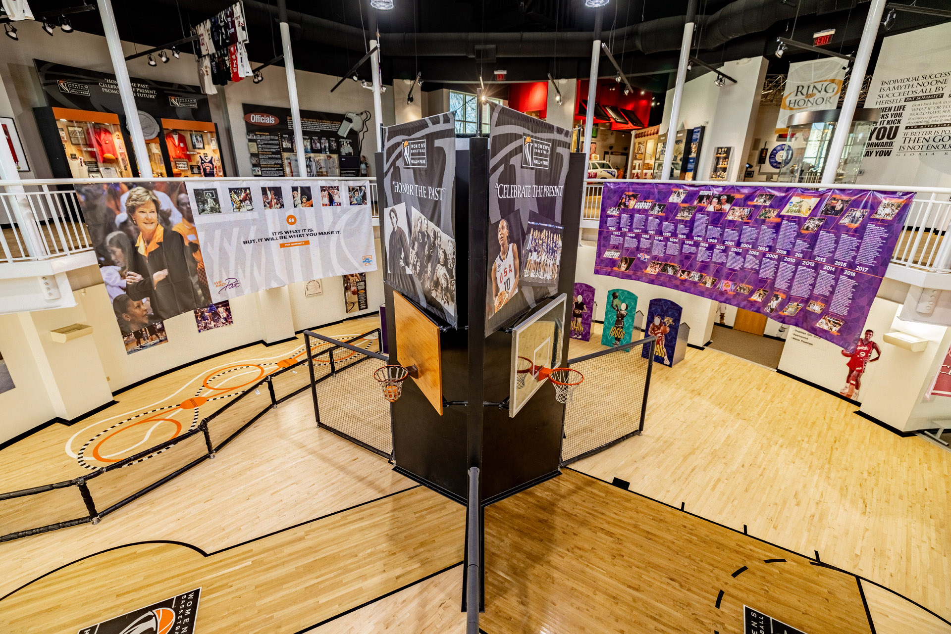 A women's basketball court in a museum with a lot of posters from the Basketball Hall of Fame.